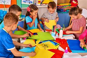 Young children gathered around a table for arts and crafts