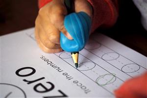 Young child tracing numbers with a pencil